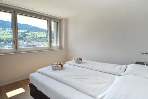 two beds in a room with a large window at Dream View Apt With Homecinema Netflix & Loggia in Luzern