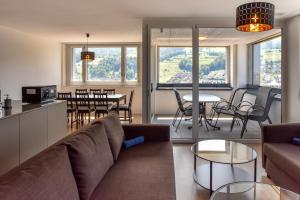 a living room with a couch and a table and chairs at Dream View Apt With Homecinema Netflix & Loggia in Luzern