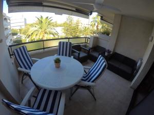 een balkon met een tafel en stoelen en een bank bij Cambrils Regata Apartamento junto el mar in Cambrils