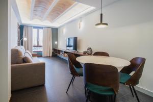 ein Wohnzimmer mit einem Tisch, Stühlen und einem Sofa in der Unterkunft Artal by CASALEA in Morella