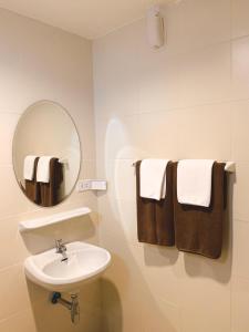 a bathroom with a sink and a mirror and towels at Baan Sooksiri Bangsaray in Bang Sare
