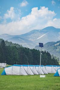 een rij tenten in een veld met bergen op de achtergrond bij GPtents- Spielberg in Spielberg