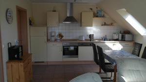 a kitchen with white cabinets and a table with chairs at Fewo Ückeritz in Ueckeritz