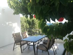 a table and chairs on a patio with a plant at Seafront Apartment in Keratokampos