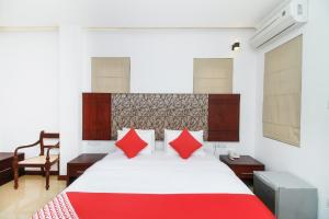 een slaapkamer met een groot bed met rode kussens bij Hotel Queensbury Malabe in Kaduwela