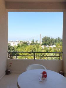 una mesa y sillas blancas en una habitación con ventana en Arilena Holiday Apartments, en Pafos