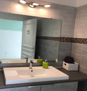 ein Badezimmer mit einem Waschbecken und einem großen Spiegel in der Unterkunft Le 81 HOTEL in Castres