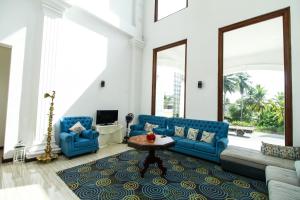 een woonkamer met blauwe banken en een tafel bij Hotel Queensbury Malabe in Kaduwela