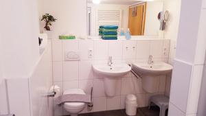 バート・ヒンデラングにあるFerienwohnung Holzheyの洗面台2つとトイレ付きの白いバスルーム +20枚の写真
