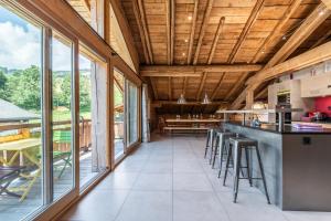 レ・ジェにあるChalet l'Arolleの木製の天井と窓が備わるオープンキッチン