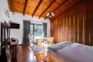 a bedroom with a bed and a table and chairs at The Anchorage Krantzkloof in Kloof