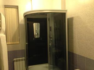 y baño con ducha y puerta de cristal. en Royal Hotel, en Járkov