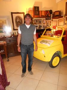 a man standing in front of a yellow truck at Hotel Rosati in Chiusi