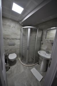 uma casa de banho com um chuveiro, um WC e um lavatório. em Queen Bee Hotel em Selçuk