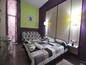 ein Schlafzimmer mit einem Bett und einer grünen Wand in der Unterkunft BARCELONA GOTIC Guesthouse in Barcelona