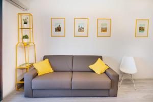 a couch with two yellow pillows in a living room at Your home in Letojanni in Letojanni