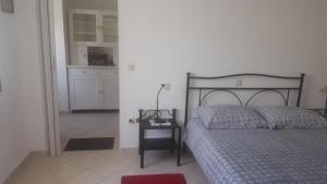 1 dormitorio con 1 cama y 1 mesa con lámpara en Villa Bruna Apartment, en Rab