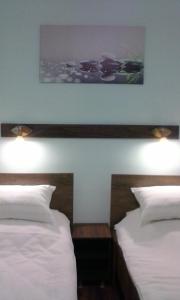 1 Schlafzimmer mit 2 Betten und 2 Leuchten an der Wand in der Unterkunft Casa TRANSILVANIA in Oradea