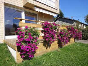 una valla de madera con flores en el lateral de una casa en Gîte Plein Sud, en Metzeral