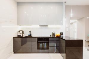 a kitchen with white cabinets and a black counter top at Z14 Boutique Residence - Krakow Old Town in Kraków