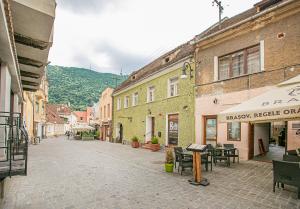 an empty street in a town with buildings at Saint John's 22 Brasov in Braşov +110 photos