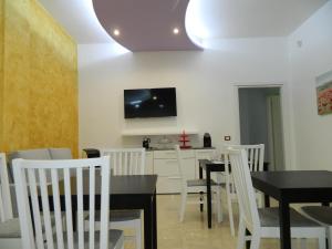 une salle à manger avec des chaises blanches et une table dans l'établissement LE STANZE DI LUCA, à Palerme