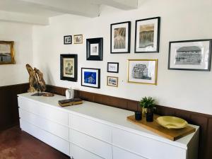a white dresser in a room with pictures on the wall at Haus Buuck - Appartement in Rüthen