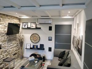 uma sala de estar com um sofá e uma parede de pedra em Gîte d'Emma em Lauret