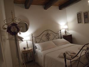 a bedroom with a bed with white sheets and two lamps at Bernardiniani Apartment in Molfetta