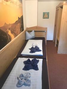 a bedroom with two beds with blue shoes on them at Gasthof zur Hoffnung in Hinterhermsdorf