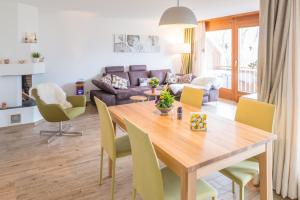 a dining room and living room with a wooden table and chairs at Casa sur Plaun - 3.5 Zimmerwohnung in Sagogn