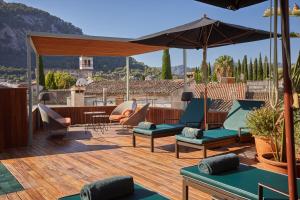 a patio with chairs and an umbrella on a deck at Mon Boutique Hotel in Pollença