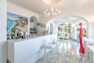 um bar com uma mulher num vestido vermelho num quarto em Hotel La Madonnina em Ischia