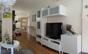 ゴールデン・サンズにあるLa Mer Residence Beach Apartmentの白いキャビネット上のテレビ付きのリビングルーム