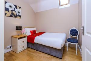 a small bedroom with a bed and a chair at Henry Court Townhouse in Kenmare