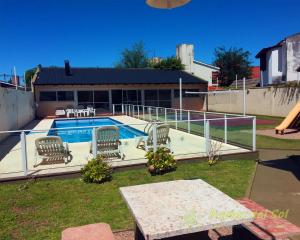a swimming pool with chairs in a yard at Duplex del Sol in Villa Carlos Paz