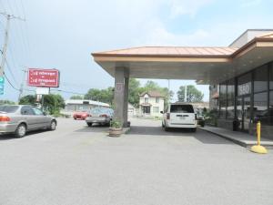 a gas station with cars parked in a parking lot at L'Auberge de l'Aeroport Inn in Dorval