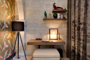 einen Schreibtisch mit einer Lampe und einem Stuhl in einem Zimmer in der Unterkunft Boutique Hôtel des Remparts & Spa in Aigues-Mortes