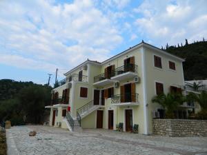 a large white building with stairs on it at Forkis Apartments in Vathi