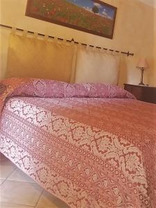 a bedroom with a bed with a pink comforter at Agriturismo Settepassi Tuscany in Ponte Buggianese