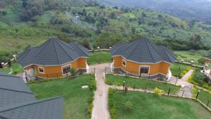 two houses with black roofs on a hill at Karobwa Summit View in Fort Portal