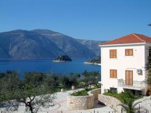 a white house with a view of a lake at Forkis Apartments in Vathi, Ithaka