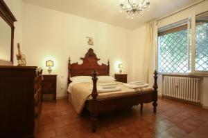 Schlafzimmer mit einem Bett und einem Kronleuchter in der Unterkunft RomagnaBNB La Tana del Grillo Parlante in Cesena