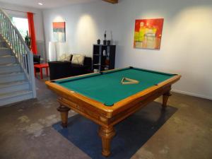 a pool table in a living room with a room with at Le Pavillon de Nathalie in Isles-sur-Suippe
