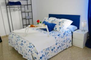 um quarto com uma cama azul e branca e uma mesa em Patios de San Rafael em Córdoba