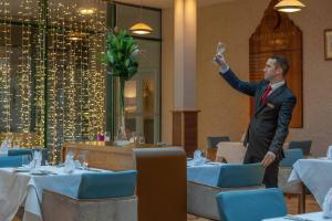 a man standing in a restaurant with a glass of wine at Castle Dargan Hotel in Sligo