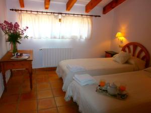 a hotel room with two beds and a table and a window at Finca El Corral in Lliber