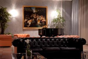 un divano in pelle nera in soggiorno con un dipinto di Hotel Palace Verona a Verona