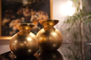 zwei goldene Vasen auf einem Tisch in der Unterkunft Hotel Palace Verona in Verona