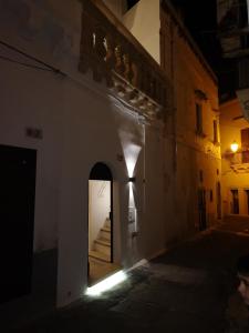an alleyway at night with a door and stairs at B & B San Giovanni 9 in Gallipoli